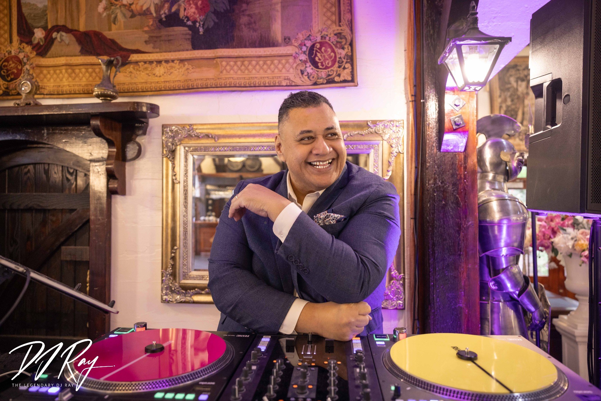 DJ Ray smiling behind his turntables at Settlers Country Manor